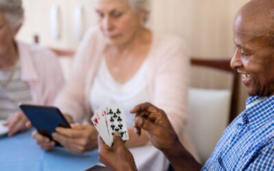 Seniors sitting at a table playing a card game