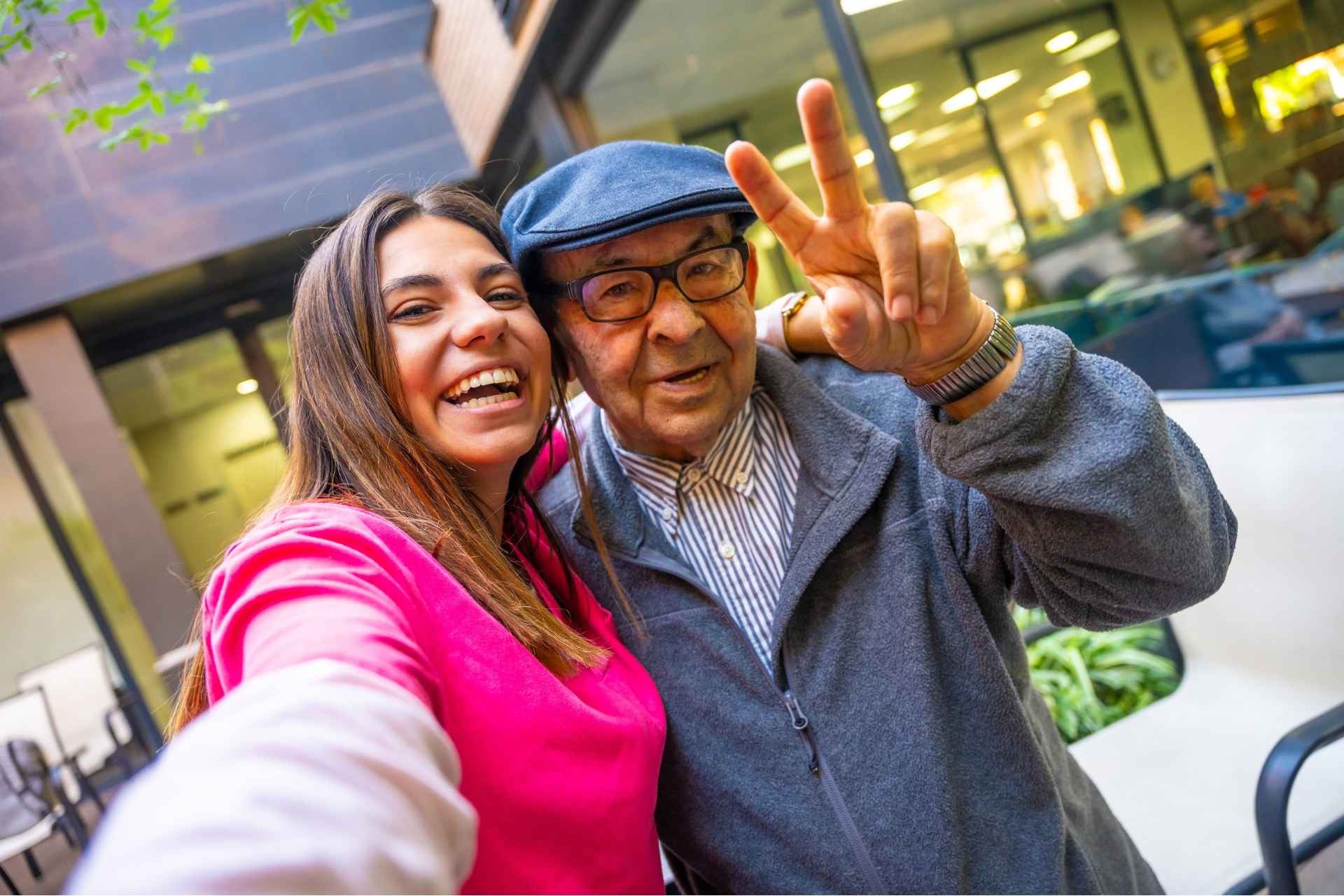 A young woman taking a selfie with her grandpa